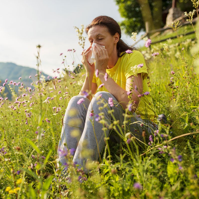 lady sneezing in flowers