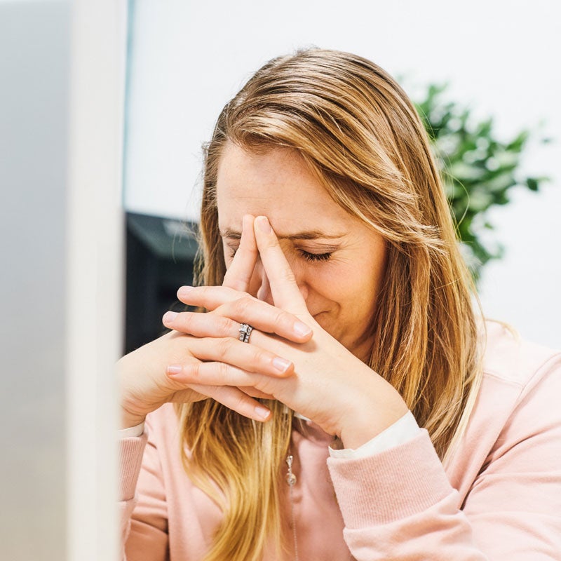 A lady holding her nose because of Sleep Apnea in Jupiter, FL