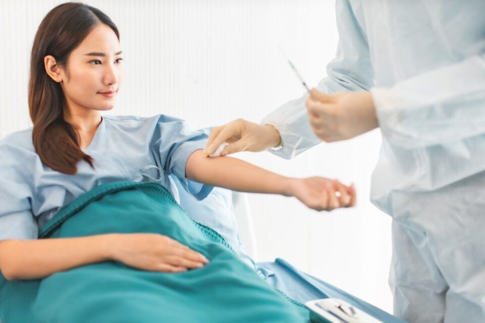A woman in a hospital gown receives an injection at ExACT Immunoplasty in Jupiter, FL